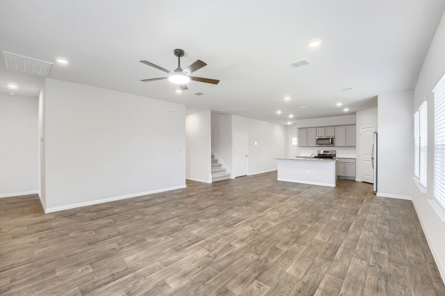 13507 Howser Trace Manor, TX 78653 - Photo 9 of 28 An open-concept living space integrates a well-appointed kitchen and dining area under recessed lighting and a ceiling fan.