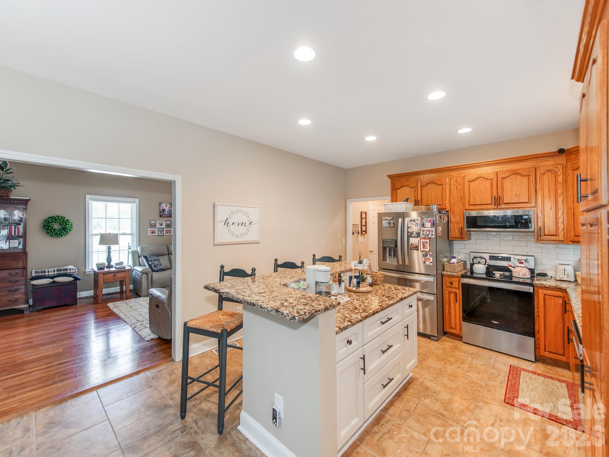 2261 Stallings Road Harrisburg, NC 28075 - Photo 16 of 41 a kitchen with stainless steel appliances granite countertop a stove top oven a refrigerator a sink and dishwasher with wooden floor