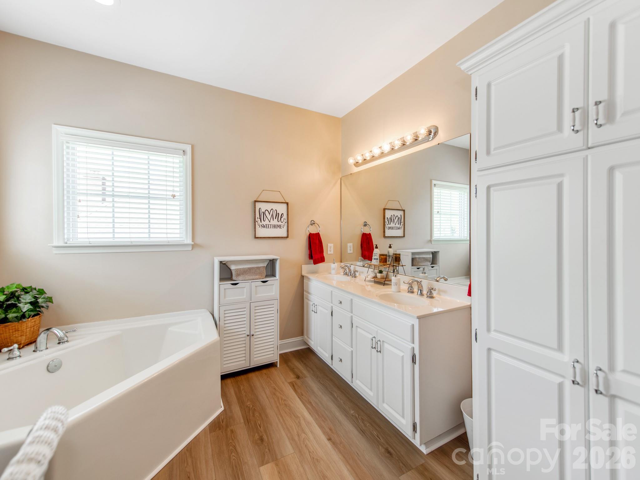 2261 Stallings Road Harrisburg, NC 28075 - Photo 21 of 41 a bathroom with a bathtub a sink and a mirror