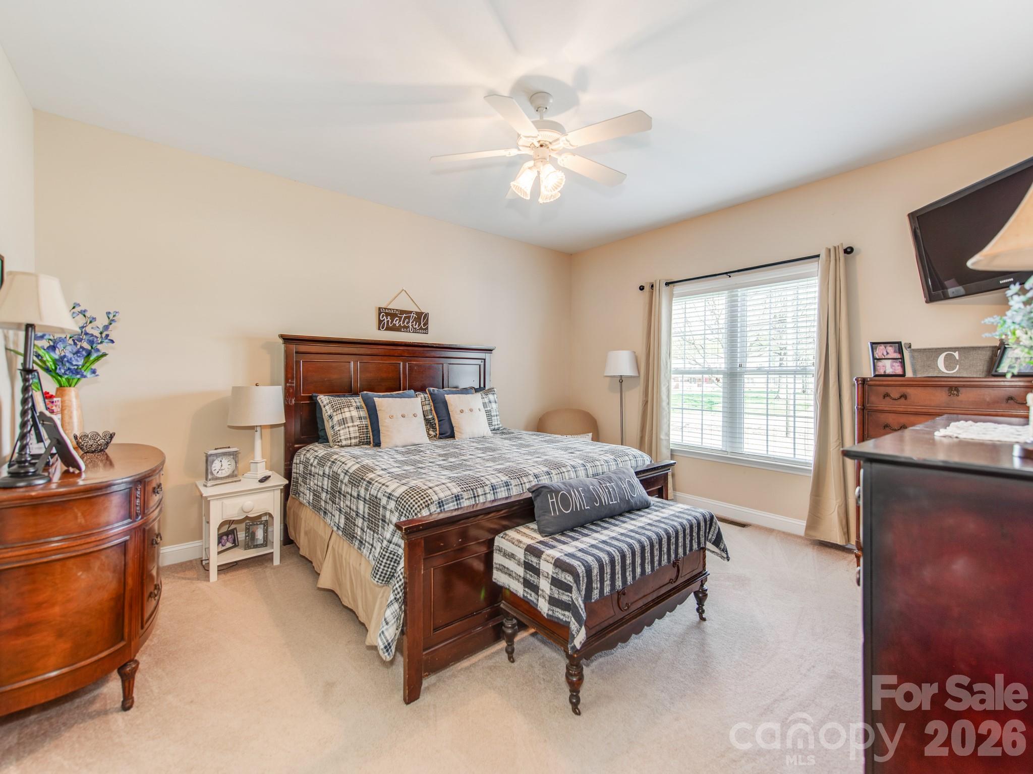 2261 Stallings Road Harrisburg, NC 28075 - Photo 24 of 41 a bedroom with a bed and a chandelier