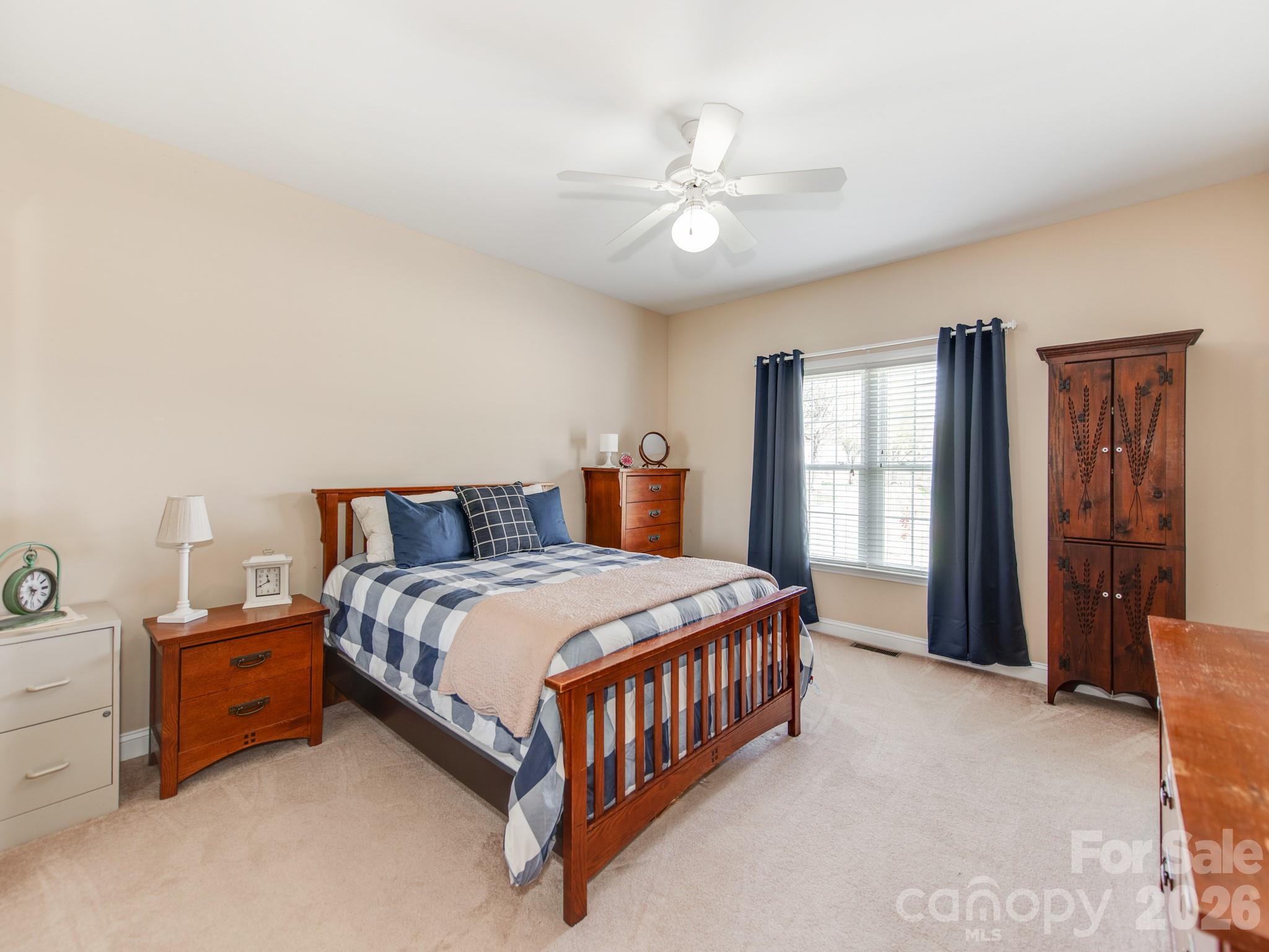 2261 Stallings Road Harrisburg, NC 28075 - Photo 27 of 41 a spacious bedroom with a bed and a chandelier
