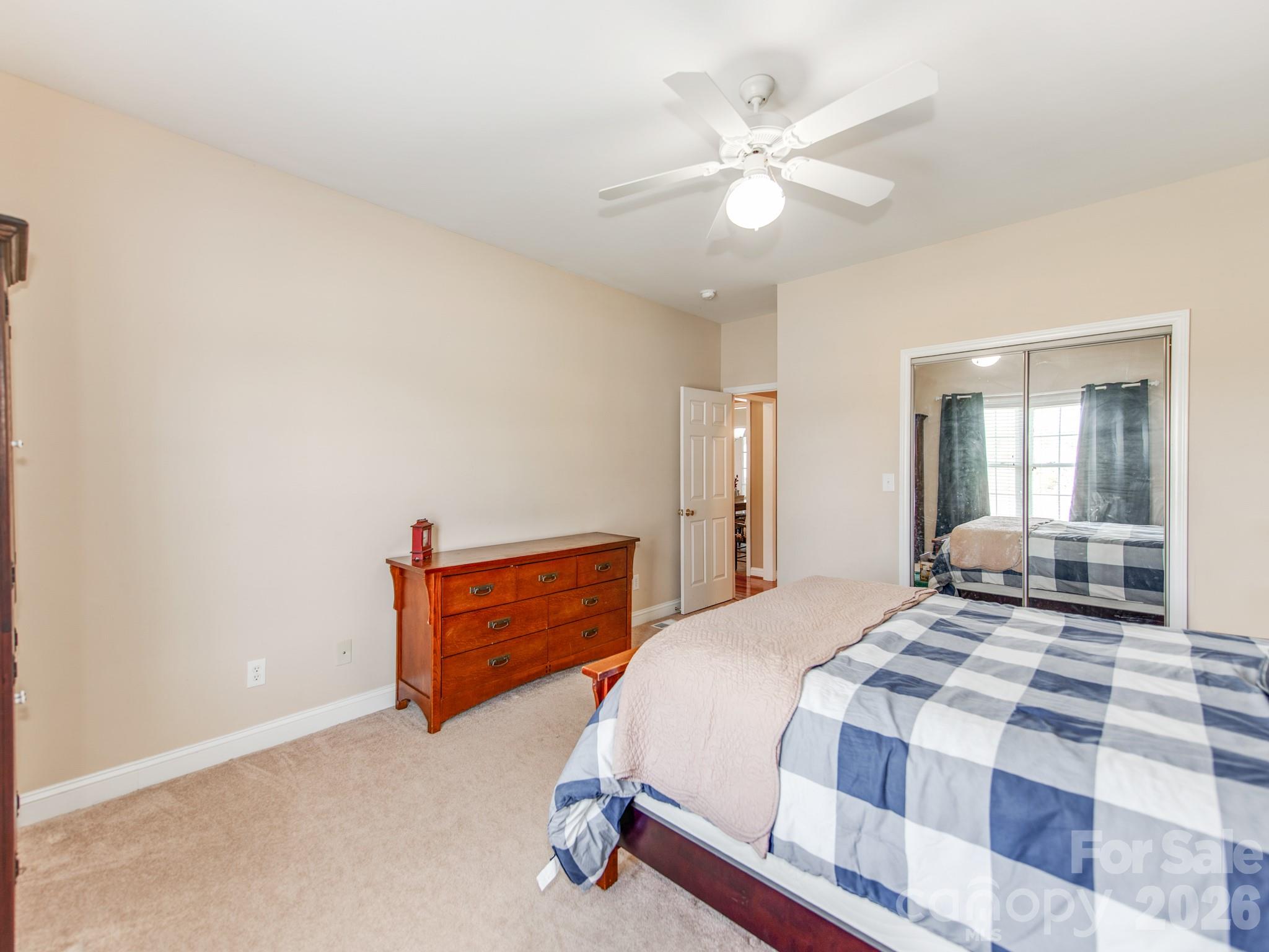 2261 Stallings Road Harrisburg, NC 28075 - Photo 28 of 41 a bedroom with a large bed and a chandelier