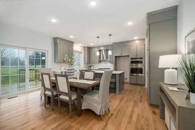 a kitchen with kitchen island wooden floors and stainless steel appliances