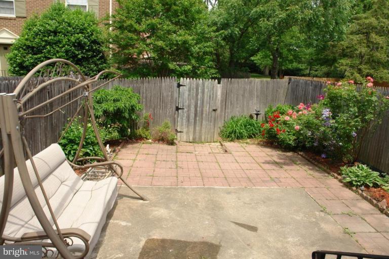 7014 Leestone Street Springfield, VA 22151 - Photo 22 of 23 a view of backyard with wooden fence and flowers