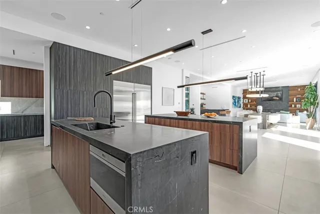 a kitchen with stainless steel appliances granite countertop a sink a stove and a refrigerator