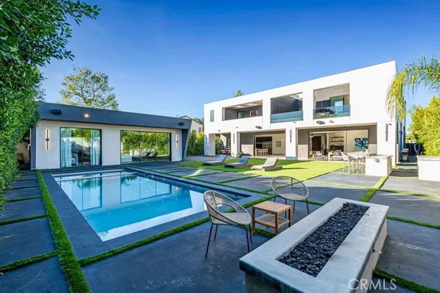 a view of swimming pool with chairs and bench