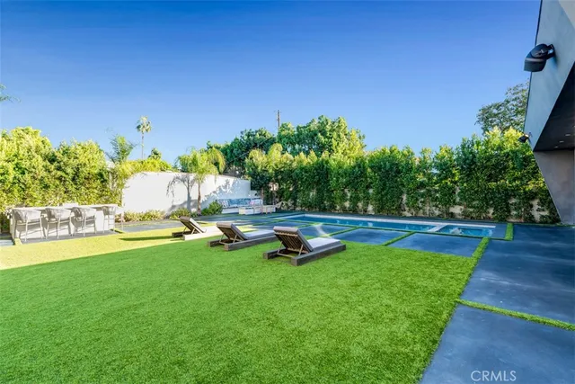 a view of swimming pool with chairs and bench
