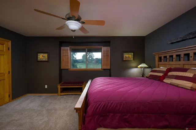 a bedroom with a bed a window and a chandelier