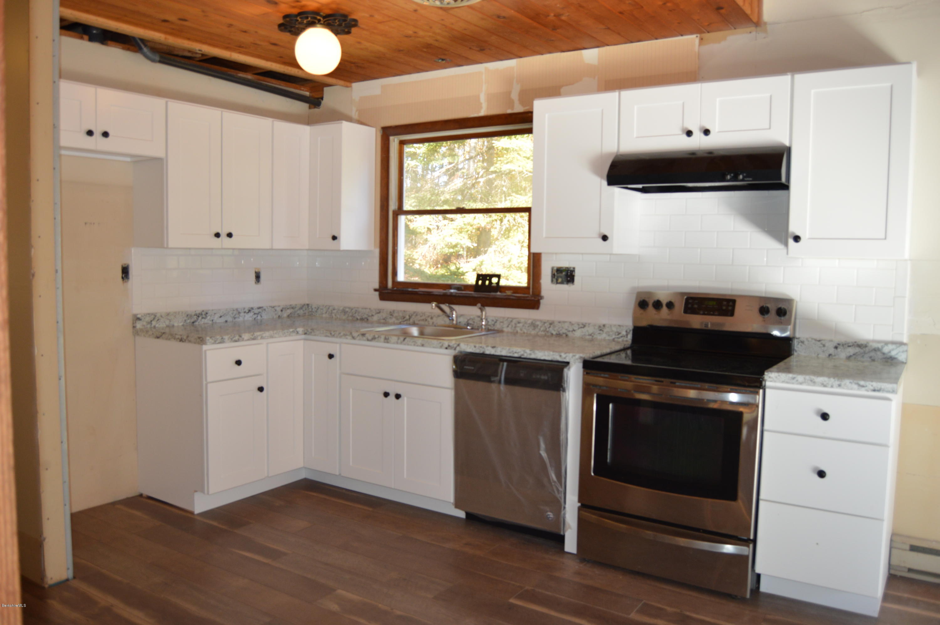 25 Davis Road Monroe, MA 01350 - Photo 11 of 27 a kitchen with granite countertop white cabinets and black appliances