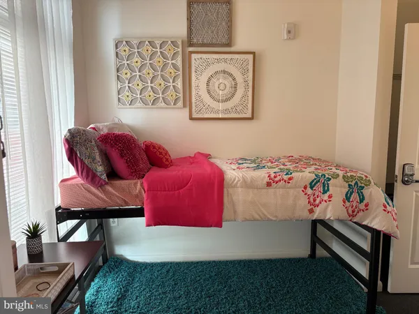 a bedroom with a bed and painting on the wall