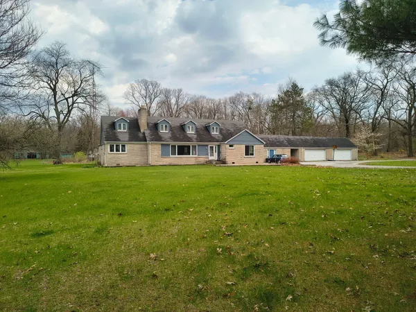 a view of a house with a big yard and large trees