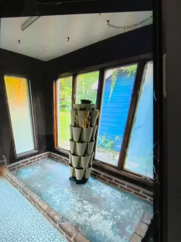 a view of an empty room with a fireplace and a window