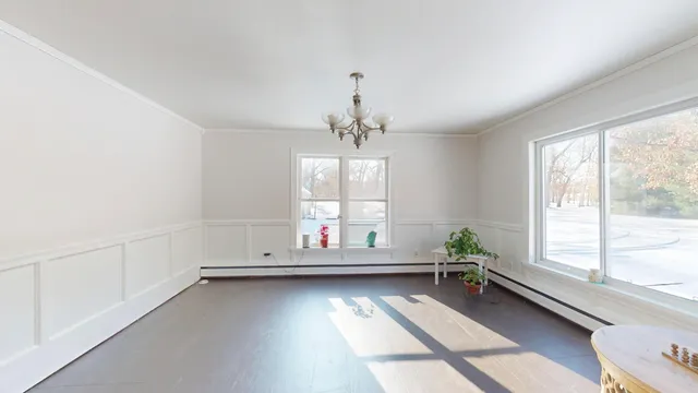 a kitchen with stainless steel appliances a sink a stove a refrigerator cabinets and a dining table with wooden floor