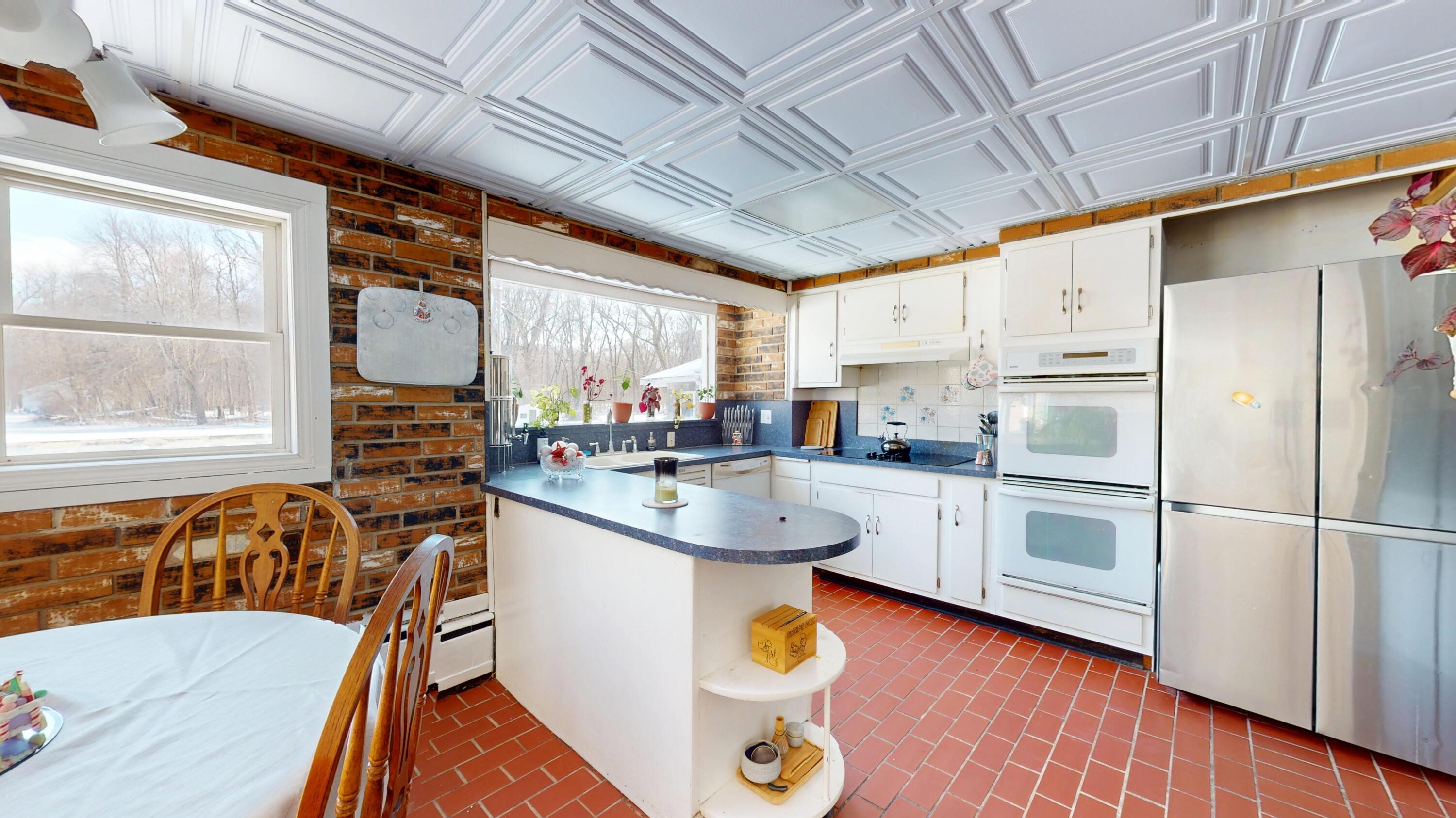 2240 South 350 East Knox, IN 46534 - Photo 55 of 103 a kitchen with stainless steel appliances a sink a stove a refrigerator cabinets and a dining table with wooden floor
