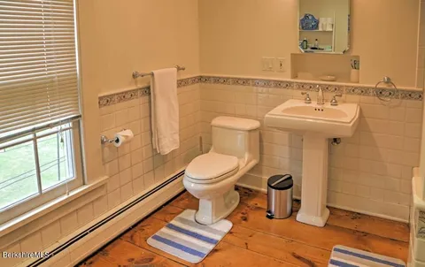 a bathroom with a toilet a sink and a mirror