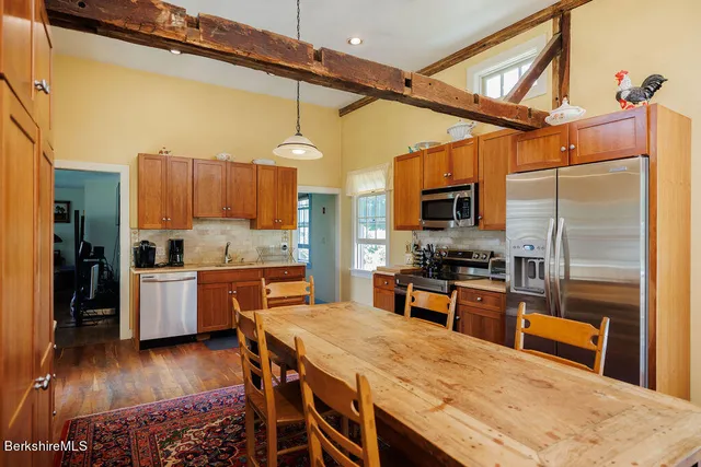 a kitchen with stainless steel appliances wooden floors and wooden cabinets