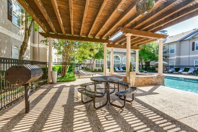 a patio with glass top table and chairs