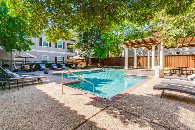 a view of a garden with potted plants and large trees