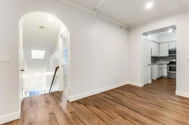 an empty room with wooden floor and a fireplace