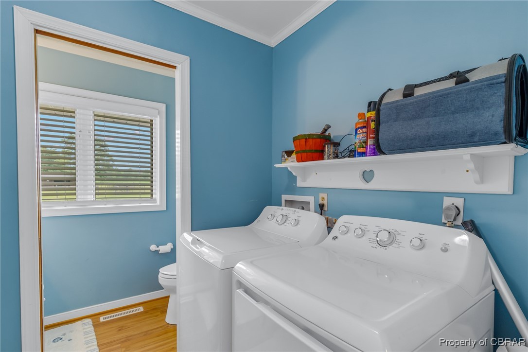 86 Greenfield Road Lancaster, VA 22503 - Photo 38 of 44 Laundry room featuring washer and clothes dryer, wood finished floors, ornamental molding, and baseboards