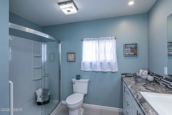 a bathroom with a granite countertop toilet sink and mirror