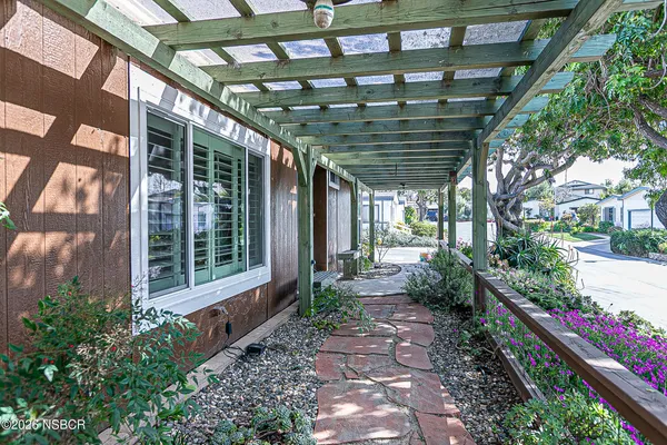 a view of house with wooden walls and potted plants