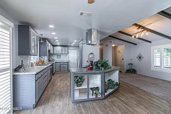 a kitchen with stainless steel appliances granite countertop a lot of counter space and wooden floor