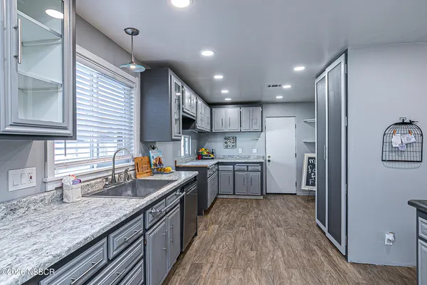a kitchen with stainless steel appliances granite countertop sink stove refrigerator and cabinets