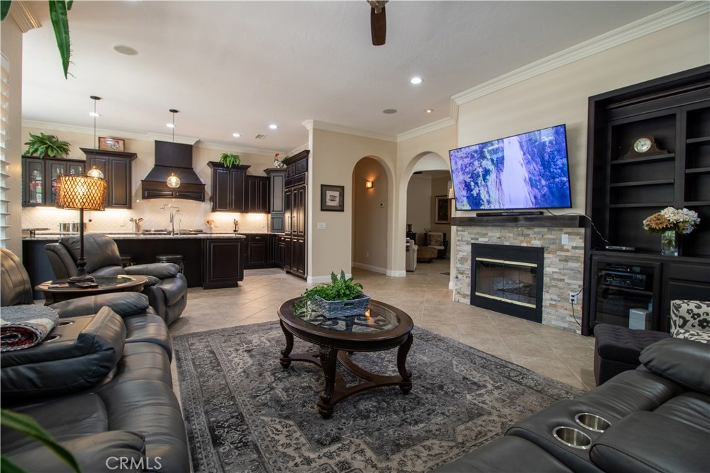 33699 Spring Brook Circle Temecula, CA 92592 - Photo 51 of 83 a living room with furniture a fireplace and a flat screen tv