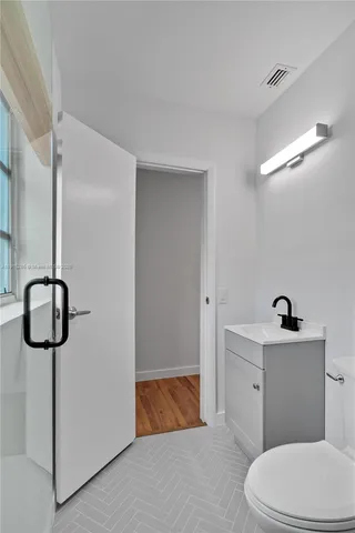 a bathroom with a toilet and a mirror