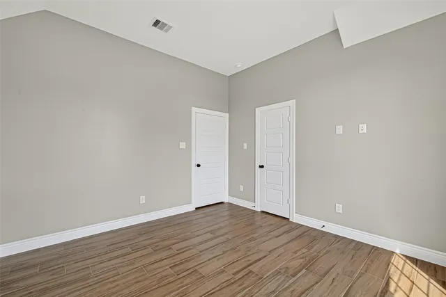 a view of an empty room with wooden floor