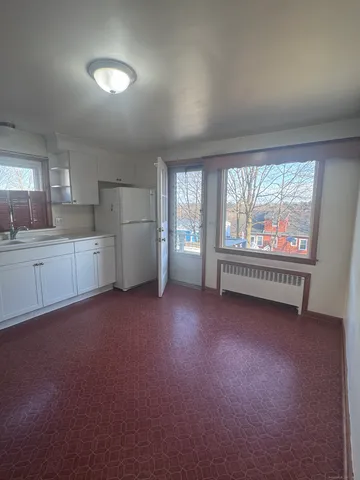 a view of a kitchen with refrigerator and window