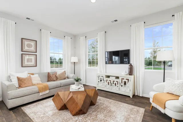 a living room with furniture a flat screen tv and a window