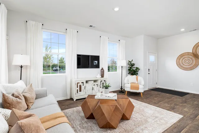 a living room with furniture flat screen tv and a large window