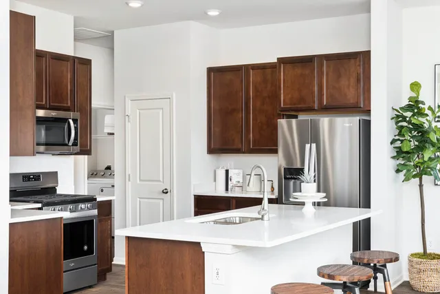 a kitchen with stainless steel appliances granite countertop a refrigerator and a stove top oven