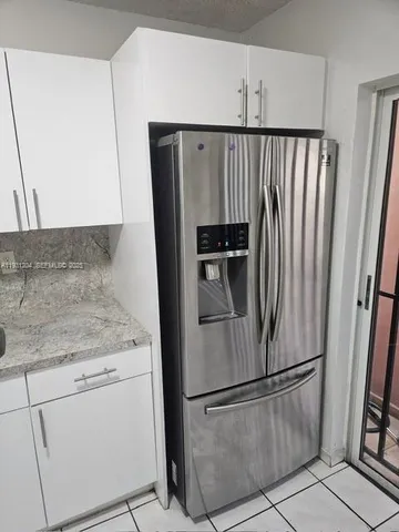 a kitchen with metallic refrigerator freezer and a dishwasher