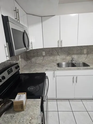 a kitchen with a sink a stove and cabinets
