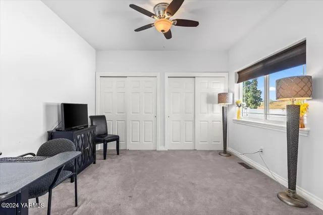 a view of a workspace with furniture and a window