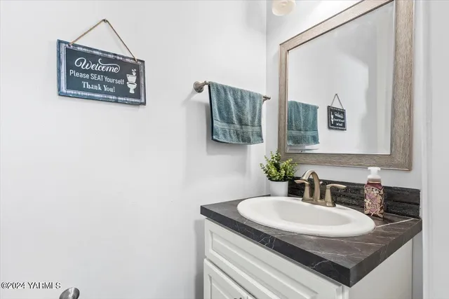 a bathroom with a granite countertop sink and a mirror
