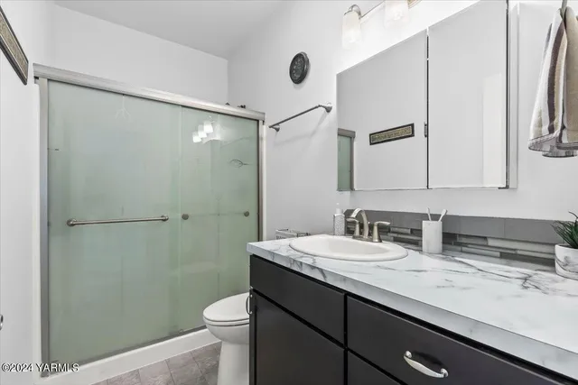 a bathroom with a sink a toilet a mirror and shower