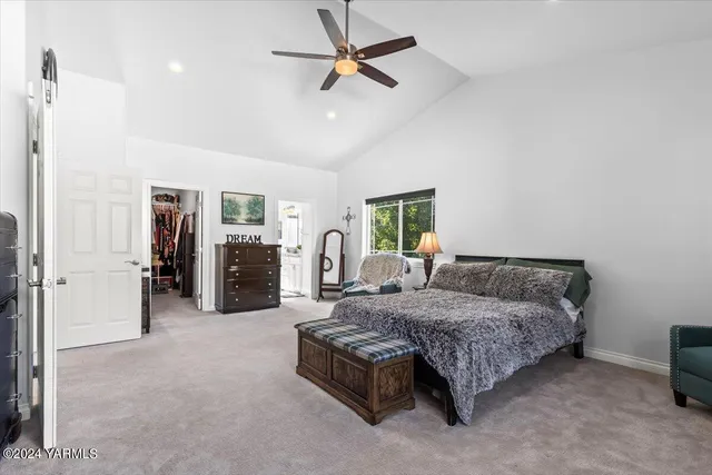 a spacious bedroom with a bed a chandelier and a couch