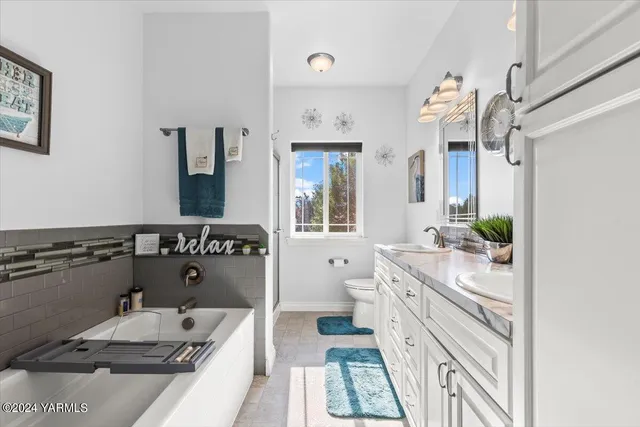 a bathroom with a tub sink and mirror