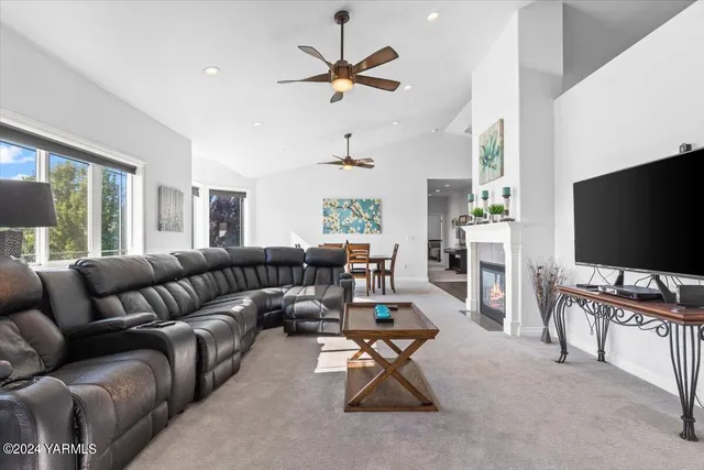 a living room with furniture a ceiling fan and a window