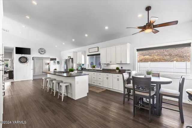 a kitchen with a dining table chairs and white cabinets