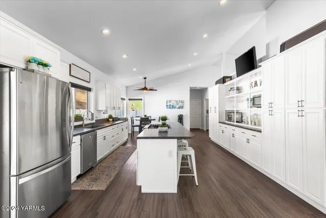 a kitchen with stainless steel appliances a refrigerator and a stove top oven
