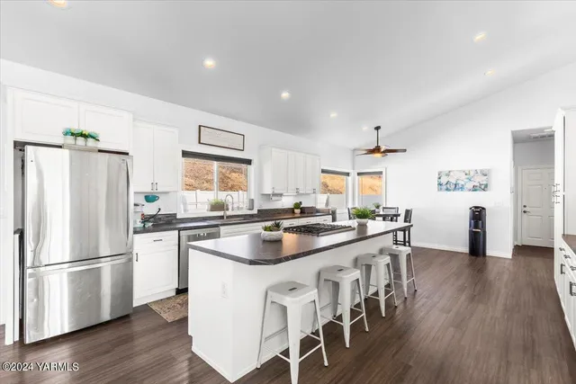 a kitchen with stainless steel appliances a stove a sink a refrigerator and island