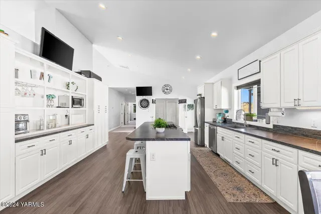 a large white kitchen with stainless steel appliances granite countertop lots of counter top space