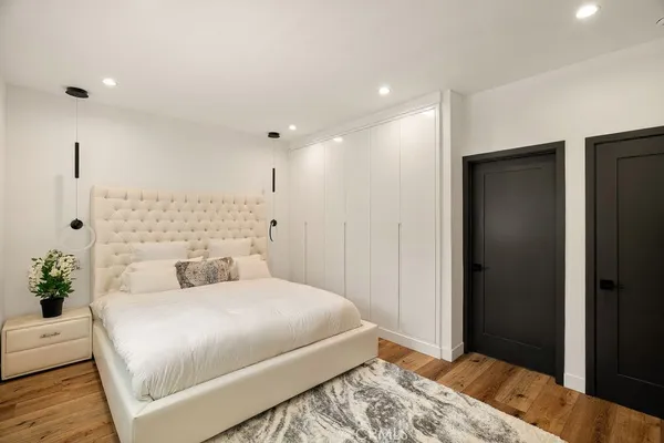 a bedroom with a large bed and a chandelier