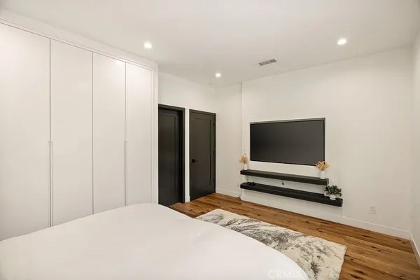 a bedroom with a bed and a flat screen tv