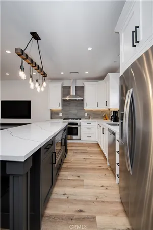 a large kitchen with stainless steel appliances kitchen island a cabinets and wooden floor